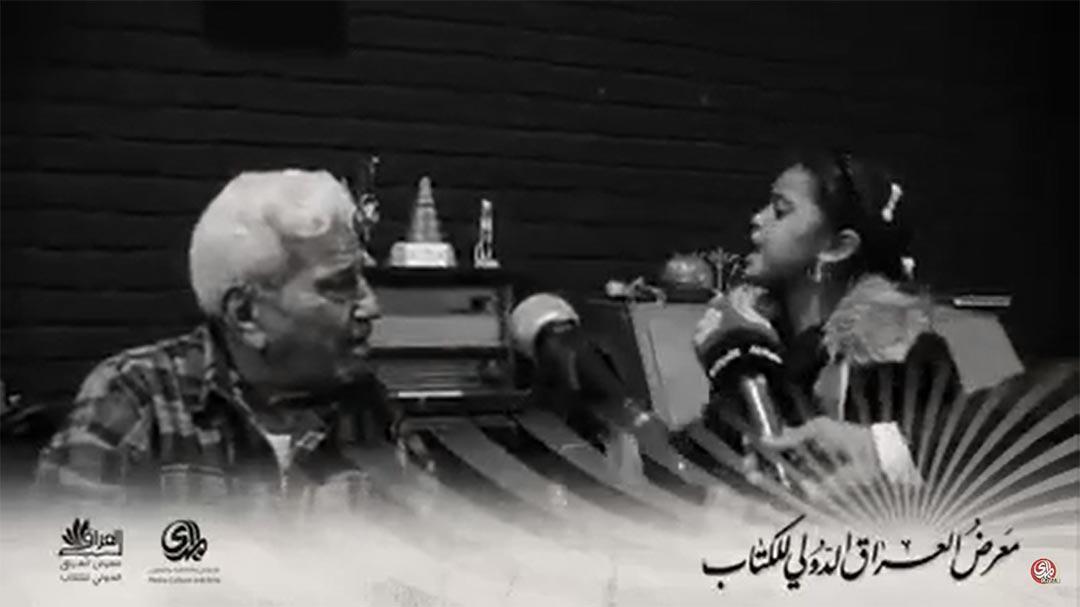 الشاعر موفق محمد، يقبل يد طفلة في معرض العراق الدولي للكتاب